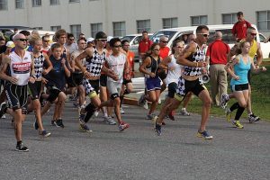 Image is a group of racers running on a city street.