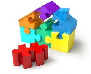 Image is a 3-D puzzle in the shape of a house, with one of the pieces out of place.