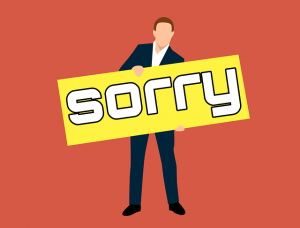 Image is an illustration of a man in a suit holding a sign that says sorry on it.